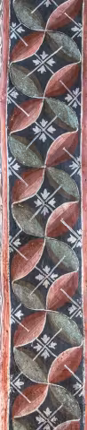 Bandă verticală îngustă cu un tipar geometric de frunze și stele în albastru, roșu și verde.