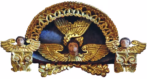 Ornament de încununare sculptat și aurit: un cap de heruvim înaripat în centru, flancat de doi îngeri înaripați.